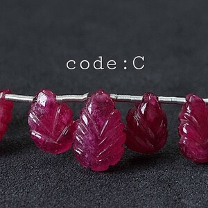 May include: A strand of pink gemstone beads in a leaf shape. The beads are strung on a silver wire. The text "code: C" is visible above the beads.