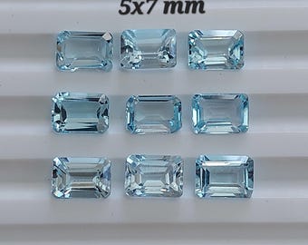 May include: Nine rectangular, light blue gemstones, each measuring 5x7 mm, are arranged in a grid pattern. The gems have a clear, faceted appearance, reflecting light. The text "5x7 mm" is displayed above the gemstones.
