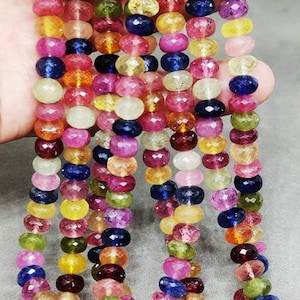 Puede incluir: Una hebra de cuentas de piedras preciosas facetadas en una variedad de colores, incluyendo rosa, azul, verde, amarillo y naranja. Las cuentas están enhebradas en un hilo transparente y tienen aproximadamente 6 mm de diámetro.