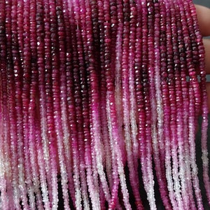 May include: A strand of pink and red ruby beads, faceted and polished, with a graduated colour effect. The beads are strung on a clear thread and are approximately 2mm in diameter.
