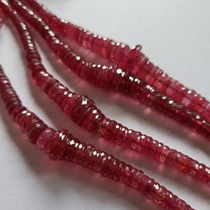 May include: A strand of faceted pink ruby beads. The beads are strung on a clear thread and are approximately 4mm in diameter.