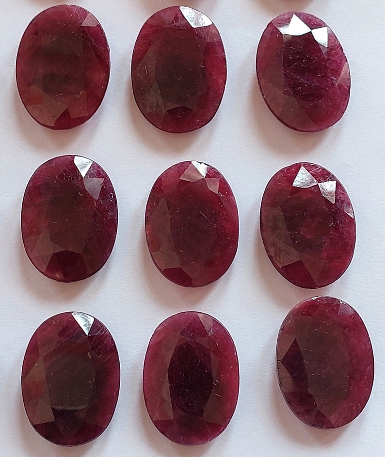 Puede incluir: Diez piedras preciosas de rub&iacute; talladas en forma ovalada. Los rub&iacute;es son de color rojo intenso y tienen un acabado pulido.