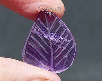 May include: A carved amethyst leaf pendant in a purple hue. The leaf has a detailed vein pattern carved into the stone. Code: D