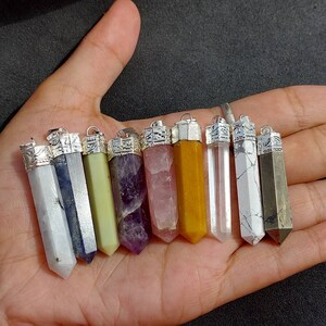 May include: Ten crystal point pendants with silver caps. The crystals are in various colors, including white, blue, green, purple, pink, yellow, and brown.
