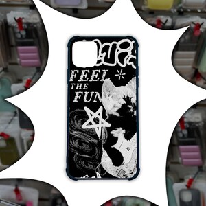 May include: Black phone case with a white and black graphic design. The design includes the words "FEEL THE FUN", a star, and a cat playing a guitar. The case has a dark blue border.