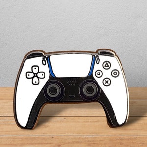 Op de afbeelding: Een witte en zwarte videogamecontroller met een blauwe accent. De controller heeft een directionele pad, vier face buttons en twee analoge sticks.