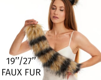 Può includere: Un set composto da un paio di orecchie da animale in pelliccia sintetica su un cerchietto e una coda in pelliccia sintetica a righe. La coda è disponibile in lunghezze di 48,26 cm e 68,58 cm. La pelliccia ha toni beige, marroni e neri.