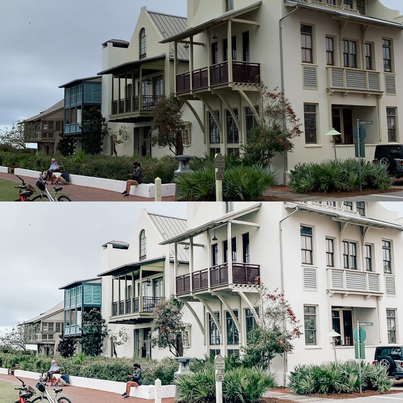May include: Two rows of white houses with balconies and railings. The houses have a light blue trim and are surrounded by lush green trees and bushes.
