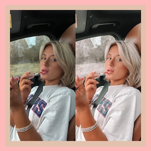 Op de afbeelding: Een vrouw in een wit T-shirt met een blauwe en rode grafische print brengt lipgloss aan in een auto.