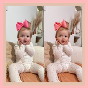 Op de afbeelding: Twee peuters die een witte pyjama dragen met een sterrenbeeldpatroon en roze strikken in hun haar. Ze zitten op een perzikkleurige bank en glimlachen naar de camera.