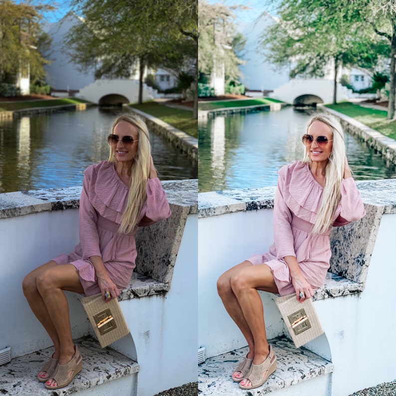 May include: A woman wearing a pink ruffled dress and sunglasses sits on a white ledge by a canal. She is holding a straw clutch.