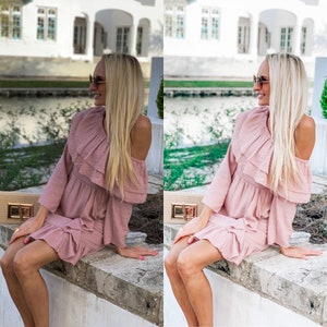 May include: A woman wearing a pink, ruffled, off-the-shoulder dress and sunglasses sits on a stone wall. She is looking to the side and has long blonde hair.