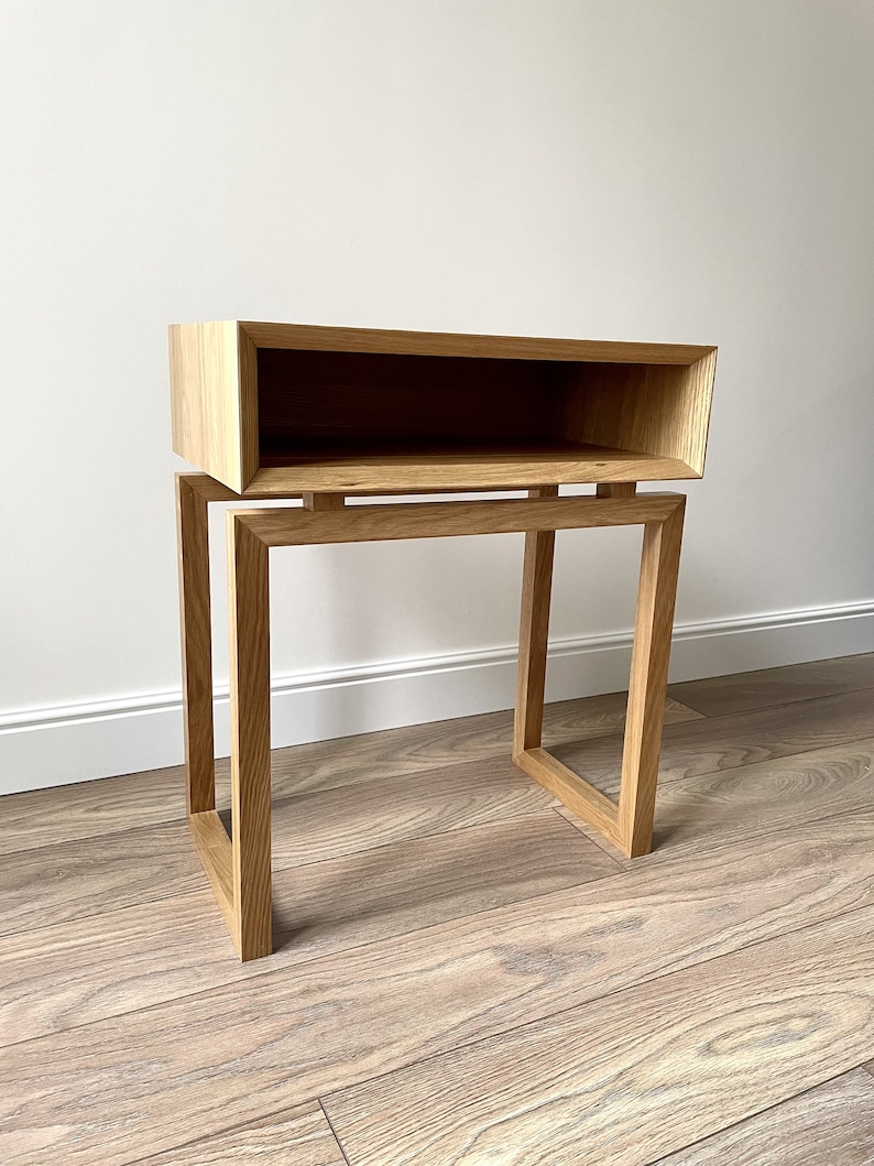 May include: A wooden side table with a shelf. The table is made of light brown wood and has a simple, modern design.
