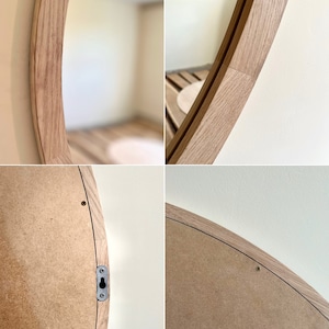 May include: A round wooden framed mirror with a natural wood finish. The mirror is hanging on a wall and the back of the mirror is visible. The back of the mirror is made of plywood and has a metal hook for hanging.