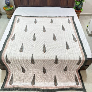 May include: White cotton quilt with a dark green leaf pattern. The quilt has a dark green border with a thin red stripe.