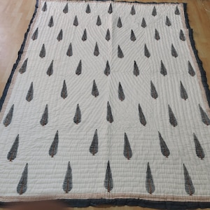 May include: White cotton quilt with a black leaf pattern. The quilt has a black border and a brown and orange trim.