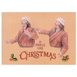 May include: A Christmas card with a brown background featuring two men in red jackets and white hats. The text "It feels like Christmas" is written in red cursive.