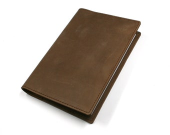 May include: A brown leather-bound journal with a stitched edge.