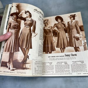 May include: A vintage magazine spread featuring women's fashion from the 1940s. The models are wearing dresses and coats with hats. The text on the page reads "New Dresses with Radiant Young Charm" and "Full Length Coat with Dress $5.98".