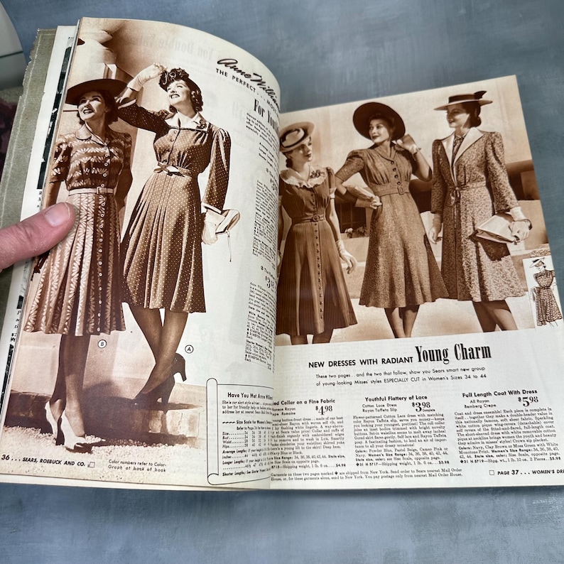 May include: A vintage magazine spread featuring women's fashion from the 1940s. The models are wearing dresses and coats with hats. The text on the page reads "New Dresses with Radiant Young Charm" and "Full Length Coat with Dress $5.98".