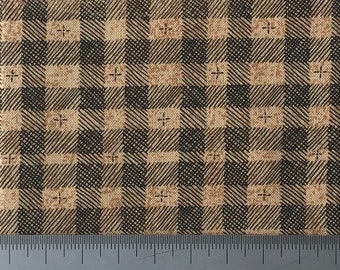 Puede incluir: Primer plano de una tela a cuadros marrón y negro con una regla que mide 127 cm.