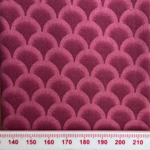 May include: A close-up of a fabric with a repeating pattern of overlapping, rounded, burgundy-colored scales.