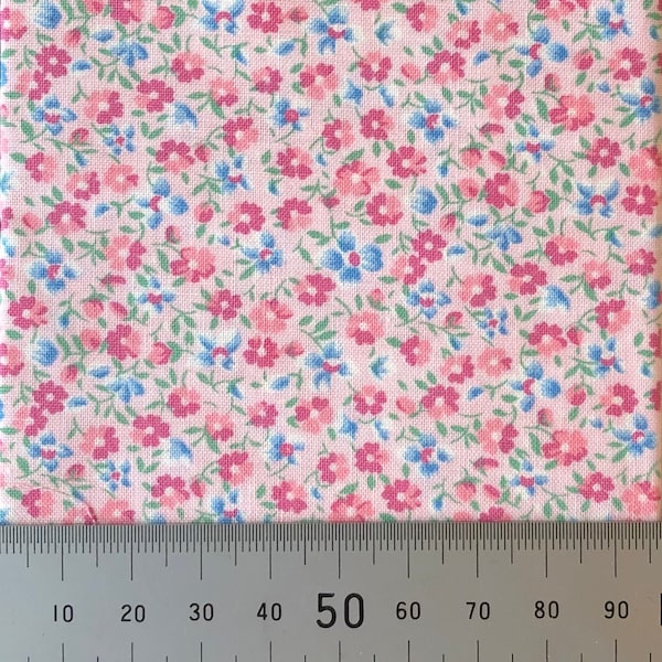 A vibrant pink cotton print of pink and blue flowers. Perfect for 1:12th scale miniatures, dolls dressmaking and patchwork quilting.