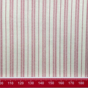 Peut inclure: Tissu blanc avec de fines rayures rouges verticales. Une règle rouge est en bas de l'image avec des chiffres de 100 à 180.