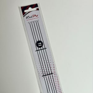 May include: Knit Pro Karbonz knitting needles, 1.00 mm, in a clear plastic package. The package has a white background with black vertical lines and the brand name in black and red. The needles are black.