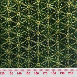 May include: Green fabric with a gold geometric pattern. The fabric is measured with a ruler that shows 120 to 200.