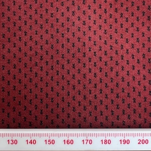 Peut inclure: Tissu rouge avec un motif répétitif noir de petits arbres stylisés. Une règle est visible en bas de l'image avec des mesures de 130 à 200.