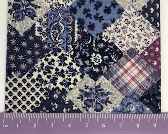May include: A patchwork fabric with a variety of blue, white, and red floral patterns. The fabric is measured with a ruler in inches.