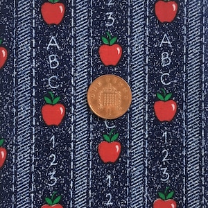 May include: Blue fabric with a repeating pattern of red apples, white numbers 1, 2, and 3, and white letters A, B, and C. A British one pence coin is in the center of the image.