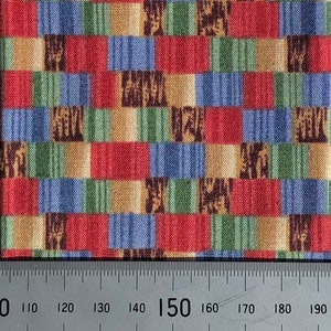 May include: A close-up of a fabric with a repeating pattern of colourful squares. The squares are in shades of red, blue, green, and brown. The fabric is textured and has a woven appearance.