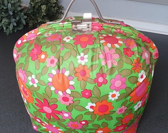 Vintage theemuts met bloemenprint uit de jaren 70 in vrolijke kleuren, inclusief glazen theepot.