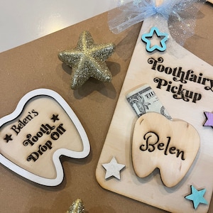 May include: Tooth fairy pickup box with a wooden tooth cutout, a dollar bill, and a star. The box is labeled "Toothfairy Pickup" and the tooth cutout says "Belen".