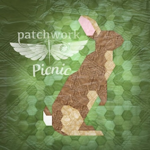 May include: A brown and tan patchwork rabbit with a pink ear, standing on a green hexagonal background. The text "patchwork picnic" is in white above the rabbit.