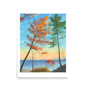 May include: A framed landscape art print featuring trees with vibrant orange and green foliage, set against a blue sky and a body of water. The artwork captures a serene outdoor scene with a touch of autumn colors.