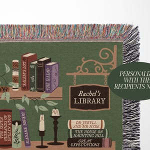 May include: A green and brown woven tapestry with a bookshelf design. The bookshelf is filled with books with titles like "The Picture of Dorian Gray", "Salem's Lot", and "The Illiad". The tapestry also features a sign that says "Rachel's Library".