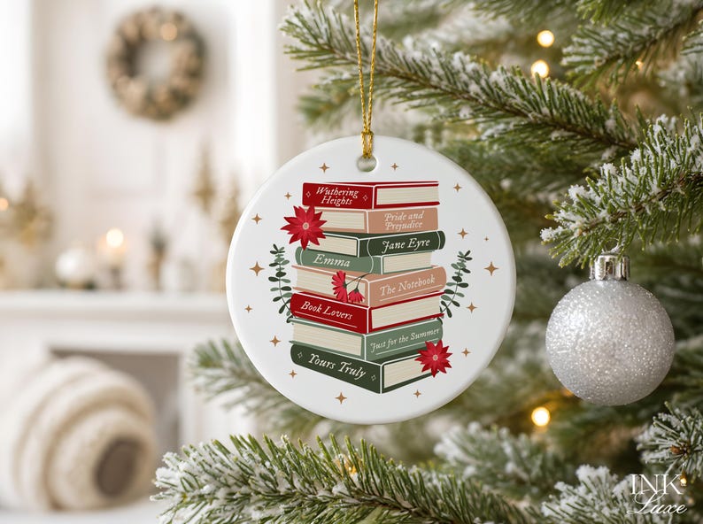 May include: A round white ceramic ornament featuring a stack of books with titles including Wuthering Heights, Pride and Prejudice, Jane Eyre, Emma, The Notebook, Book Lovers, Just for the Summer, and Yours Truly, accented with red poinsettias and gold stars.