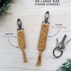 May include: Two macrame keychains, one in a petite size measuring 6 inches or 15 centimeters long and one in a large size measuring 7 inches or 18 centimeters long. Both keychains are made with a mustard yellow cord and have a tassel at the bottom.