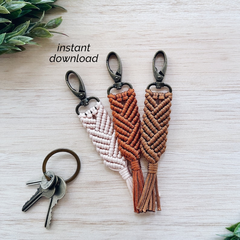 May include: Three keychains with a braided tassel design in shades of brown, orange, and pink. Each keychain has a silver metal clasp.