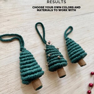 May include: Three green yarn Christmas tree ornaments with bells and a red and white wreath on the top. The ornaments have a brown yarn base and a loop for hanging.