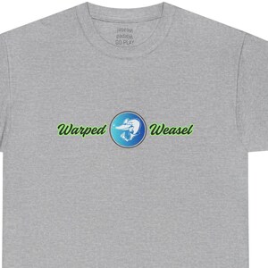 Puede incluir: Camiseta gris con la frase "Warped Weasel" en verde y un gráfico azul y blanco de una comadreja. La camiseta es de cuello redondo.