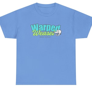 Puede incluir: Una camiseta azul claro con el texto "Warped Weasel" en verde y azul, y un dibujo de una comadreja. La frase "Born to Play" está impresa debajo del texto principal.