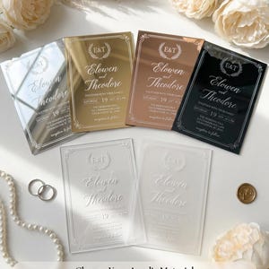 Vellum wrap tied over a wedding invitation with baby's breath, dried pampas grass and a gold monogram wax seal