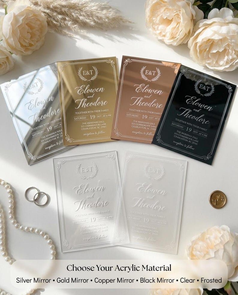 Vellum wrap tied over a wedding invitation with baby's breath, dried pampas grass and a gold monogram wax seal