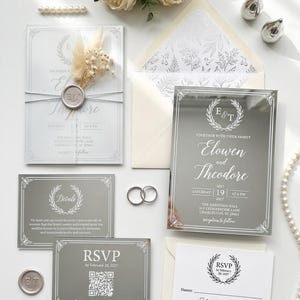 Hand-pressed gold wax seal with couple initials on a vellum wrapped wedding invitation