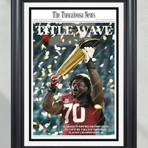 Może przedstawiać: Oprawiony wydruk z pierwszej strony The Tuscaloosa News. Nagłówek brzmi "TITLE WAVE" nad zdjęciem zawodnika futbolu amerykańskiego trzymającego trofeum. Zawodnik ma na sobie karmazynową koszulkę z numerem 70. Widoczny jest również tekst "ALABAMA OVERWHELMS OHIO STATE TO CAPTURE COLLEGE FOOTBALL PLAYOFF CHAMPIONSHIP".