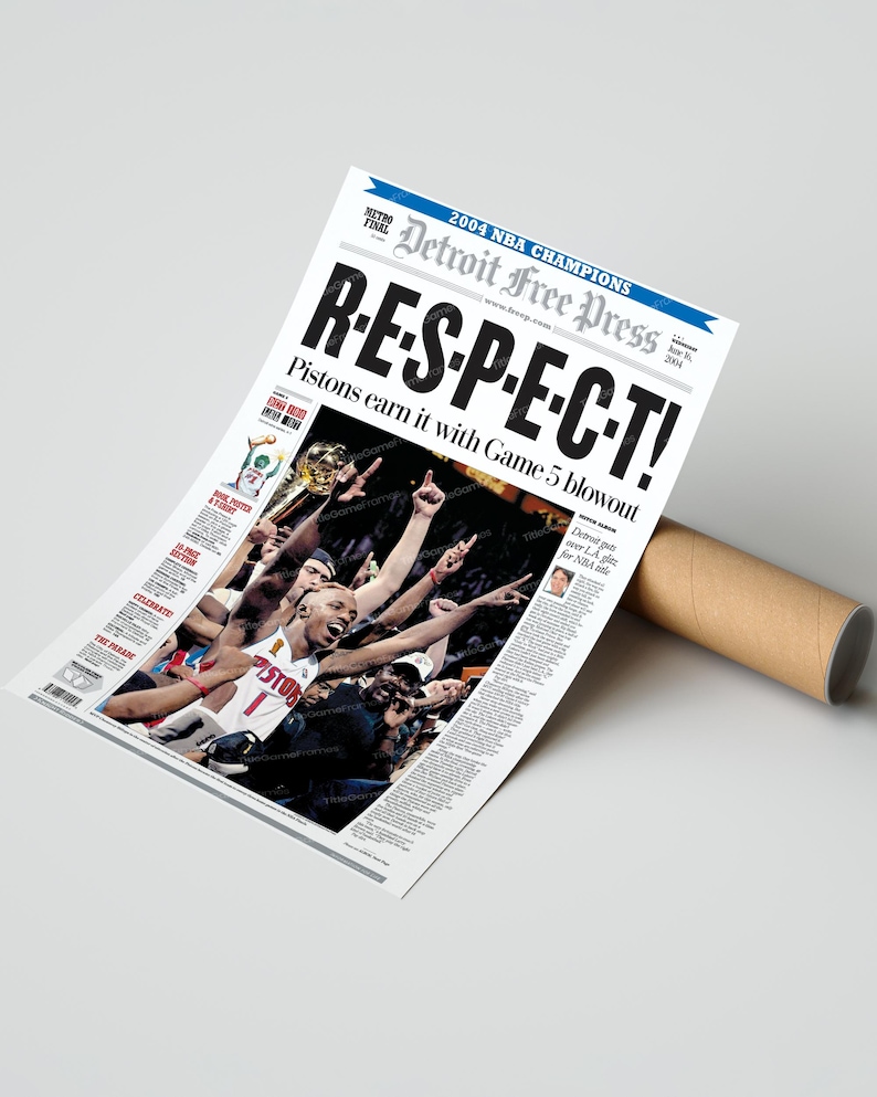 Może przedstawiać: Plakat z gazety upamiętniający Detroit Pistons, mistrz&oacute;w NBA w 2004 roku. Nagł&oacute;wek brzmi "R-E-S-P-E-C-T!" z podtytułem "Pistons earn it with Game 5 blowout". Plakat jest zwinięty z brązową tekturową tubą.